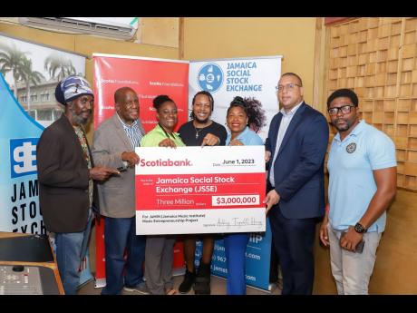 Dr Henley Morgan (second left), founder of the Agency for Innercity Renewal (AIR), accepts a donation of $3 million from Scotiabank’s Perrin Gayle (second right), executive vice president for retail and SME banking, to support the Jamaica Music Institute