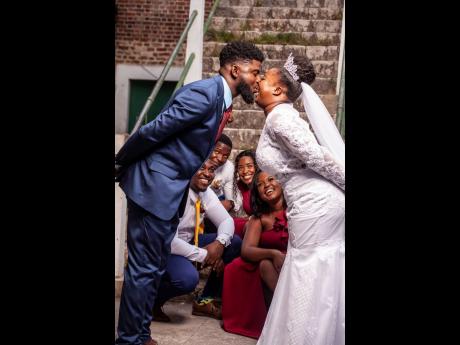 The bride and groom share a sweet moment with their supportive bridal party. 