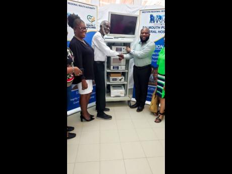 Credit: Contributed Patrick Williams, president of Jamaica Awareness Association of California Inc (right), makes the presentation of a laporoscopy machine to Dr Leighton Perrin of Falmouth Hospital. At left is CEO Princess Wedderburn.