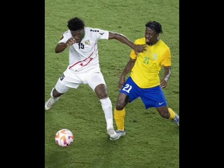 Credit: Courtesy of @goldcup St Kitts and Nevis’ Mervin Lewis (left) shields the ball away from French Guiana’s Loïc Baal during their Concacaf Gold Cup qualification game at the DRV PNK Stadium in Fort Lauderdale, Florida, on Tuesday.