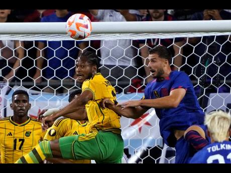 Jamaica midfielder Kevon Lambert (centre)  and United States defender Matt Miazga (right) battle for the ball during the first half of their Concacaf Gold Cup  match last Saturday in Chicago. The game ended in a 1-1 draw.