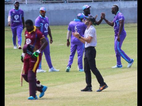 Andre Russell (right)  is congratulated by his Surrey Kings teammates after picking up a wicket against the Cornwall Warriors in the Dream XI Jamaica T10 at Sabina Park yesterday. 