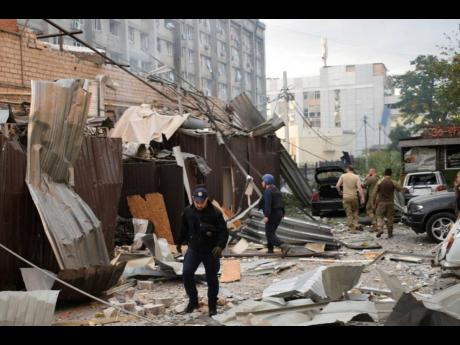 A police officer and a rescue worker walk in front of a restaurant, RIA Pizza, destroyed by a Russian attack in Kramatorsk, Ukraine, on Tuesday.