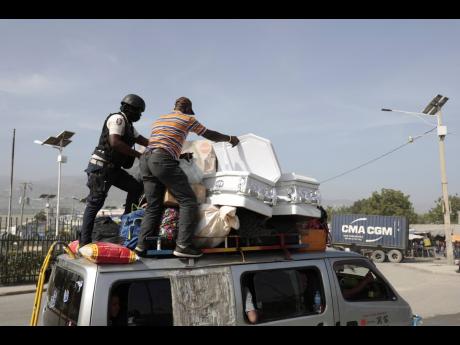 A policeman checks a public transport driver’s cargo that includes coffins, in Port-au-Prince, Haiti.