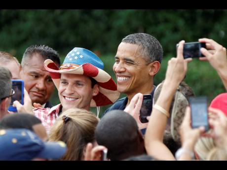 President Barack Obama poses for a photo during a visit with service members at the White House Independence Day celebration July 4, 2012, on the South Lawn of the White House in Washington. 