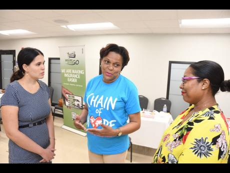 Credit: Contributed With the collection target of 30 units of blood met at the mid-way mark of the GenAc blood drive, the manager of fundraising and operations at Chain of Hope, Nola Phillpotts Brown (centre), explains the impact with Embassy of Cuba in Jamaica diplomat Anabe