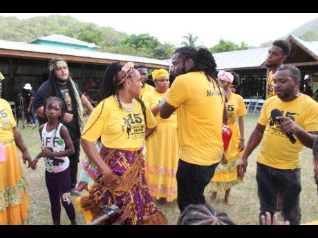 The Charles Town Maroon Singers and Dancers, and Ras Padam (second from right), engage in a spirited dance.