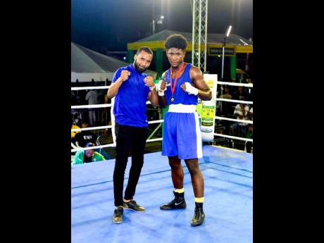 Credit: Contributed Trade marketing coordinator at Pepsi-Cola Jamaica Alessandro Boyd jumps into the ring to hand over a medal to Ackeem Francis, winner of the third amateur fight of the Wray & Nephew Fight Nights series in the middleweight category.
