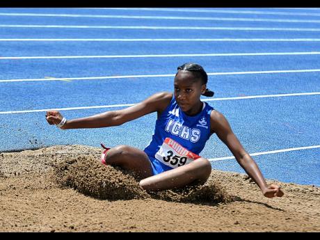 Jaeda Robinson lands in the sandpit on her way to the under-18 girls triple jump title during the National Senior and Junior Championships on inside the National Stadium today.