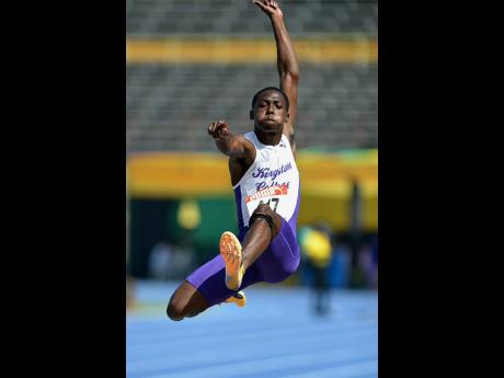 Credit: Kenyon Hemans Kingston College's Royan Walters leaps into the sand pit at the National Stadium earlier today on his way to winning the boys' under-20 National Senior and Junior Championships long jump title.