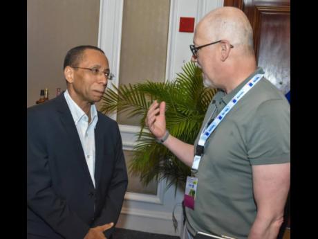 Joseph Holness (left), JNGI assistant general manager for reinsurance and underwriting, in discussion with Frank Buchsteiner, senior executive for client management with the Germany-based Munich Re at a recent cocktail reception in Montego Bay.