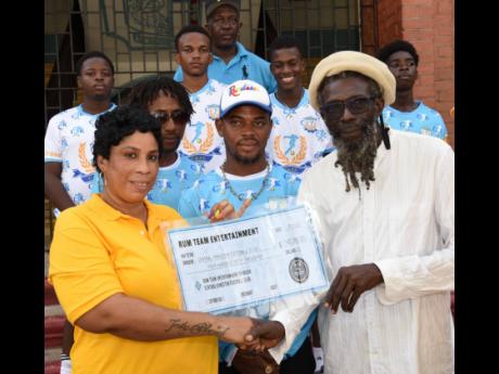 Credit: Ian Allen Rum Team Entertainment’s Ava Oakley (left) presents a sponsorship cheque and football gear to Ansel Lee, executive secretary of Central Kingston Football Club during a presentation at St George’s College yesterday. Looking on are other members of the C