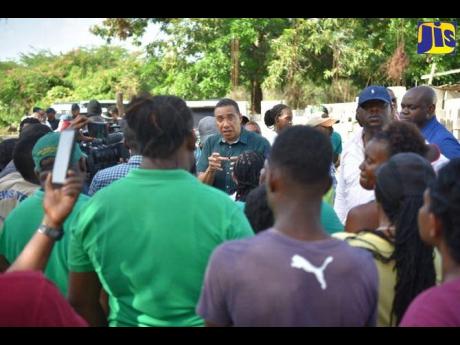 Prime Minister Andrew Holness (centre) speaking to residents of Clarendon during a visit to several communities in the parish on Wednesday, July 12.