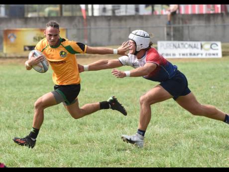 
Jamaica’s Matteo Cherwayko (left) tries to escape the attentions of USA South’s Stone Wilkinson during the Rugby Americas North final at the UWI Bowl yesterday.