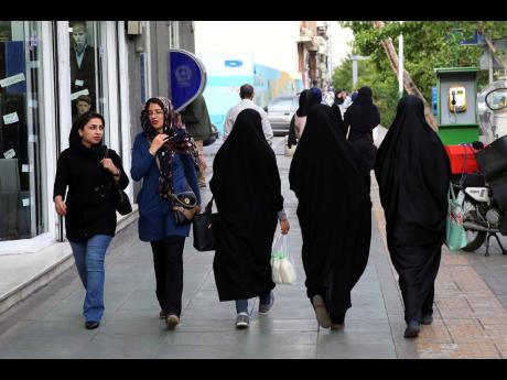 Iranian women make their way along a sidewalk in downtown Tehran in this 2016 photo. 