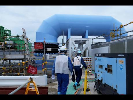 Officials of Tokyo Electric Power Company Holdings give Associated Press journalists a tour to show part of the facility for the release of treated radioactive water to sea from the Fukushima Daiichi nuclear power plant in Futaba town.