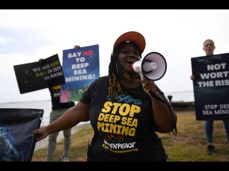 Dahvia Hylton leads climate advocates in a protest yesterday against Deep Sea mining at the Kingston, Waterfront, adjacent to the Jamaica Conference Centre.