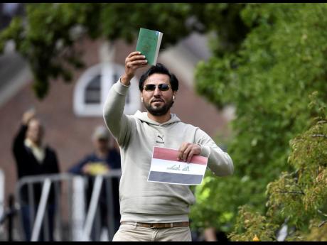 Protester Salwan Momika appears outside the Iraqi embassy in Stockholm, where he planned to burn a copy of the Quran and the Iraqi flag. 