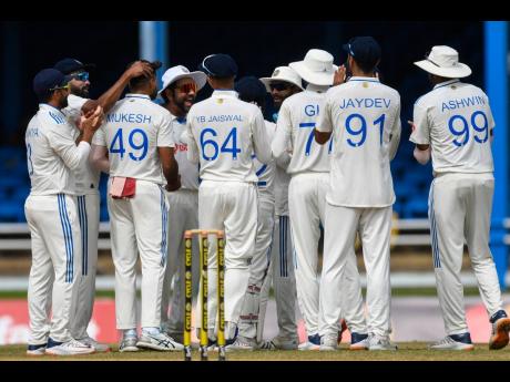 India’s players celebrate the fall of a West Indies wicket at Queen’s Park Oval in Trinidad and Tobago, yesterday.  