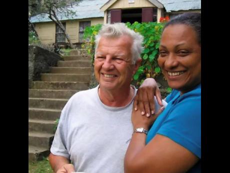 Maurice John and his wife of 55 years, Sheila pose in front of the 230-year-old Whitfield Hall Hostel before it was destroyed by fire last July.