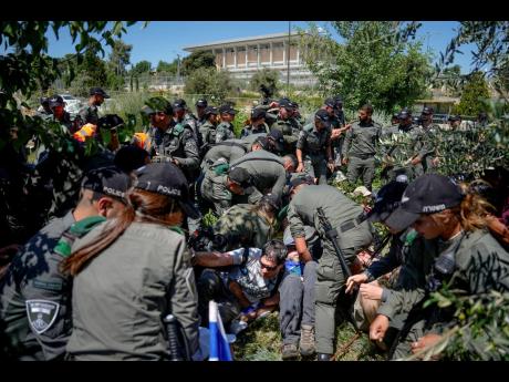 Israeli border police officers scuffle with demonstrators during a protest against plans by Prime Minister Benjamin Netanyahu’s government to overhaul the judicial system, outside the Knesset, Israel’s parliament, in Jerusalem on Monday.