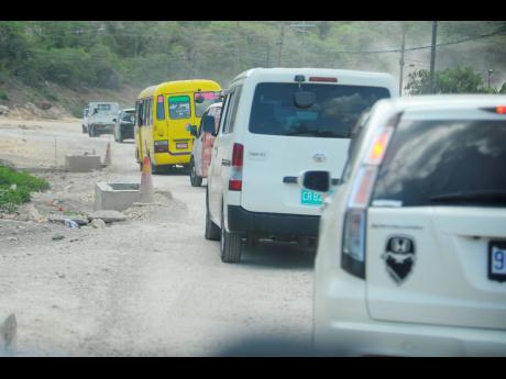 This June photo taken in  Eight Miles, Bull Bay, St Thomas, shows vehicles negotiating a narrow stretch of the road. Peter Espeut writes: We are now almost at the end of July, and they say that SCHIP should be complete by the end of August.  Hardly likely!