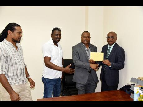 New Savanna-la-mar Deputy Mayor Ian Myles (second right) accepts a gift from Councilor Rudolphe Uter, (right) on his formally taking office while looking on are Jamaica Labour Party Councillor Lee Simpson and Councillor Garfield James.