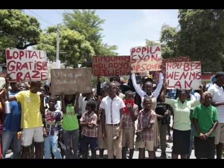 Students from the El Roi academy carry signs during a demonstration to demand the freedom of New Hampshire nurse Alix Dorsainvil and her daughter, who have been reported kidnapped, in the Cite Soleil neighbourhood of Port-au-Prince, Haiti.