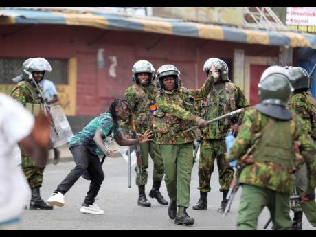  Police clash with a man during a protest by supporters of Kenya’s opposition leader Raila Odinga over the high cost of living and alleged stolen presidential vote, in Nairobi, on March 20.
