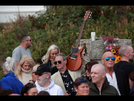 Fans gather outside the former home of Sinead O’Connor ahead of the late singer’s funeral in Bray, Wicklow county, Ireland.