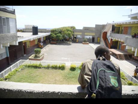 A student overlooks the courtyard at Donald Quarrie High School. 