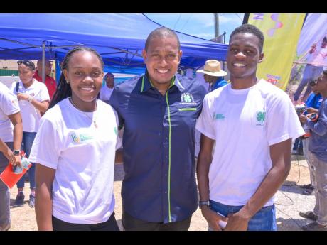 Minister of Agriculture, Fisheries and Mining Floyd Green (centre) shares a photo with Jamaica 4-H Clubs Champion Boy Ishmael Smythe and Champion Girl Natoya Williams, during the recent Denbigh Agricultural, Industrial, and Food Show at the Denbigh Showgro