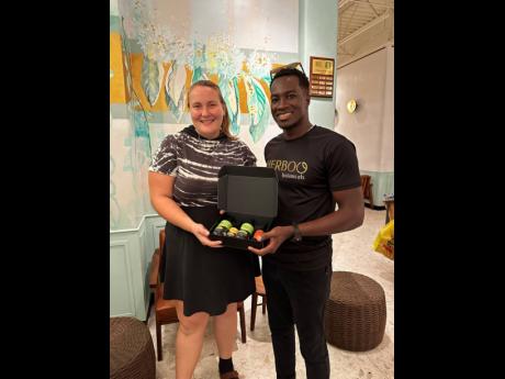 Chief executive officer of Herboo Botanicals, Javin Williams (right), hands over a taste of Herboo to Birgitta Fontel. 