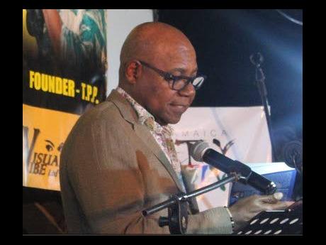 Credit: Paul H. Williams Tourism Minister Edmund Bartlett reading from a book he has co-authored with Professor Lloyd Waller.