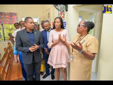 Minister of Agriculture, Fisheries and Mining, Floyd Green; Member of Parliament Manchester Central Rhoda Moy Crawford (centre); and Nurse Maxine Isaacs lead the touring party through the newly refurbished Broadleaf Health Centre, after it was officially r