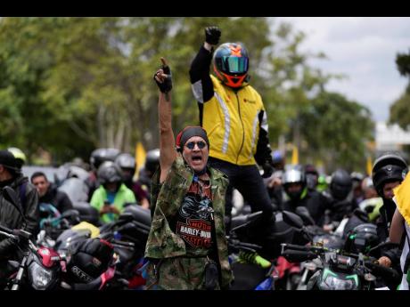Motorcycle riders shout slogans against the government during a caravan to protest the increase in gas prices in Bogota, Colombia, on Monday.
