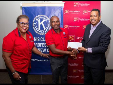 The Community Health Programme of the Kiwanis Club of 23 East Professionals St Andrew Online has received a boost from CIBC FirstCaribbean. Here, the club’s Dwayne Bender (centre) and Judith Montague receive a cheque from the bank’s Managing Director N