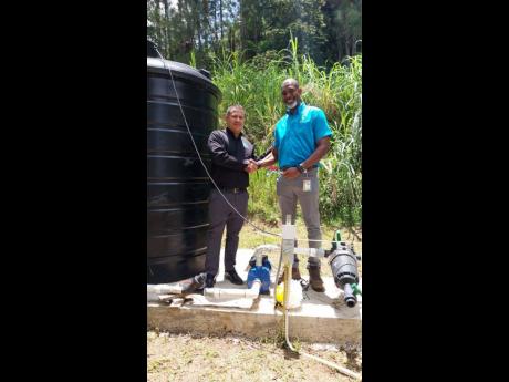 Senator Matthew Samuda (left), minister without portfolio in the Ministry of Economic Growth and Job Creation, and Ainsley Henry, CEO & conservator of forests at the Forestry Department, shake hands after the ribbon-cutting for the commissioning of the new