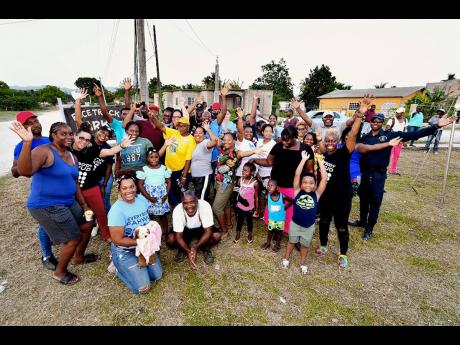 Community members from Racetrack in May Pen take a group photo with team members from Project STAR at the open day, which was held recently.