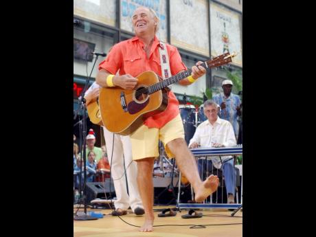 Singer Jimmy Buffet performs barefooted with his band The Coral Reefers on the NBC Today television show summer concert series in New York’s Rockefeller Plaza, in June 2004. 