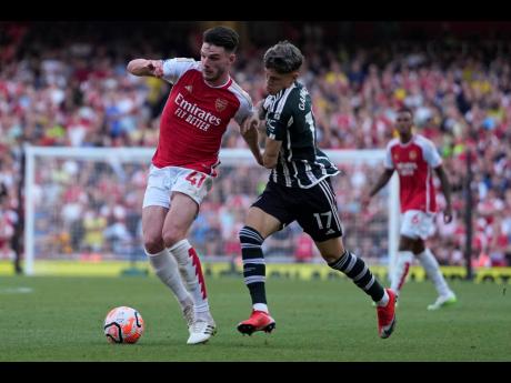 Arsenal’s Declan Rice (left) is challenged by Manchester United’s Alejandro Garnacho during the English Premier League soccer match between Arsenal and Manchester United at Emirates stadium in London yesterday.