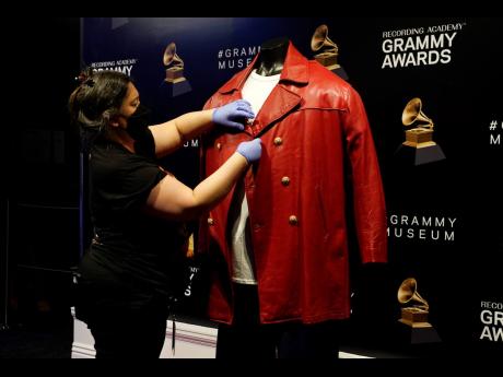 Credit: AP Collections assistant Cyrene Cruz primps a red leather jacket that was worn by the late rapper The Notorious B.I.G. in preparation for the exhibit.