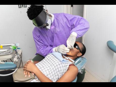 Dr Randolph Morgan administers teeth cleaning within DentCare’s cutting-edge mobile unit.
