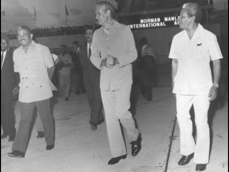 Michael Manley (centre) on his way to board the Air Canada flight at the Norman Manley Airport in March 1974 which took him to Canada for talks with his counterpart, Pierre Trudeau. Seen with him, in similar attire, are Noel Silvera, minister of home affai