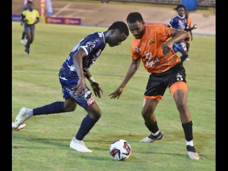 Giovanni Taylor (left) of Jamaica College dribbles past Daeshawn Tate (right) of Tivoli Gardens High during the first match of the 2023 Manning Cup football season at the National Stadium on Saturday. Jamaica College won 2-0. Ian Allen/Photographer