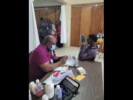 Credit: Contributed Dr Robert Clarke with a patient during the medical mission.