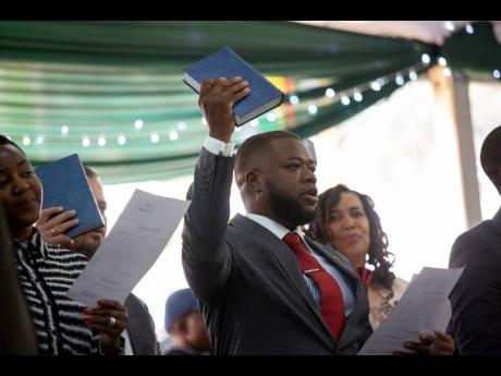Zimbabwe’s president’s son, David Kudakwashe Mnangagwa, takes his oath as he is sworn in as deputy finance minister at State House in Harare, Zimbabwe, on Tuesday.