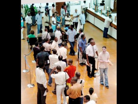 Persons waiting in line to conduct business at the Constant Spring Tax Office.