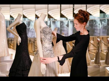 A curator adjusts a creation, which is displayed as part of the “Gabrielle Chanel. Fashion Manifesto” exhibition at the Victoria and Albert museum in London.