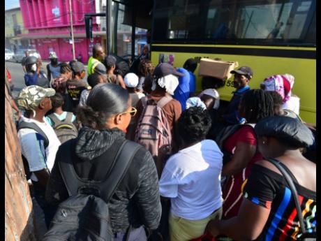 In this file photo, commuters are seen jostling to get into a JUTC bus.